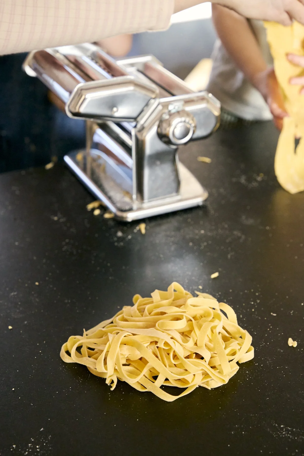 Frisk pasta og en pastamaskine på køkkenbordet